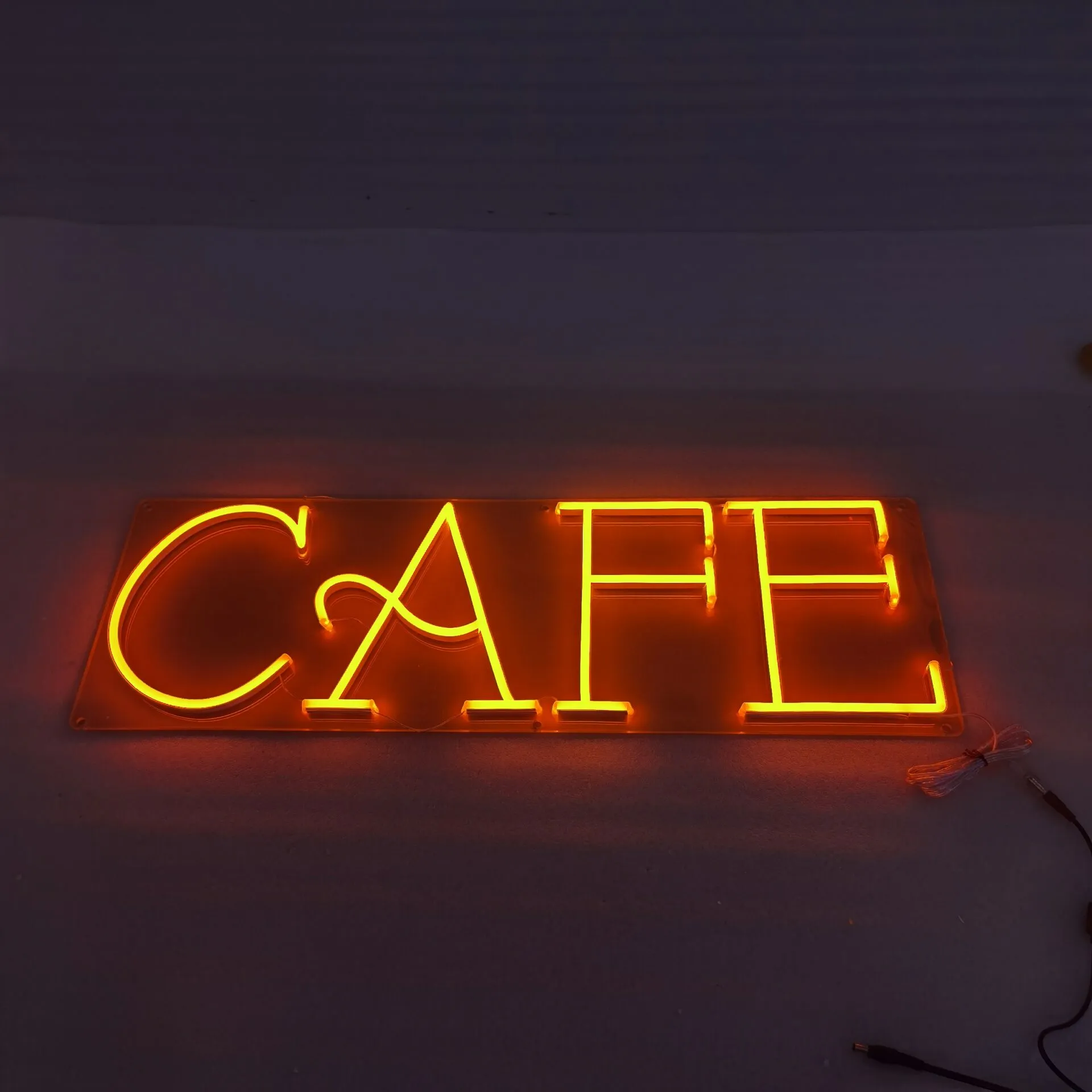 Custom LED neon sign for cafe restaurant in warm white lettering installed above counter in Sydney