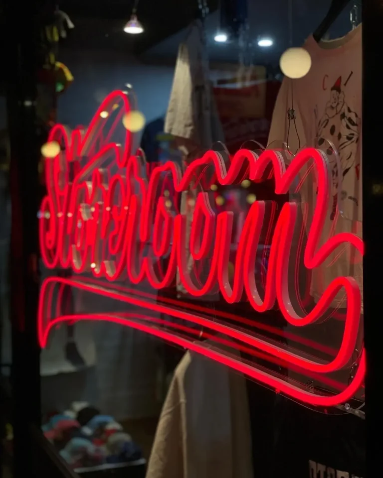 Red script LED neon sign displayed in a retail store window in Australia