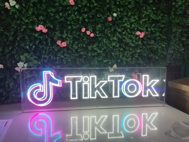 Pink script LED neon sign reading Coffee Coffee Coffee Before We on a purple wall perfect for a cafe or home decor