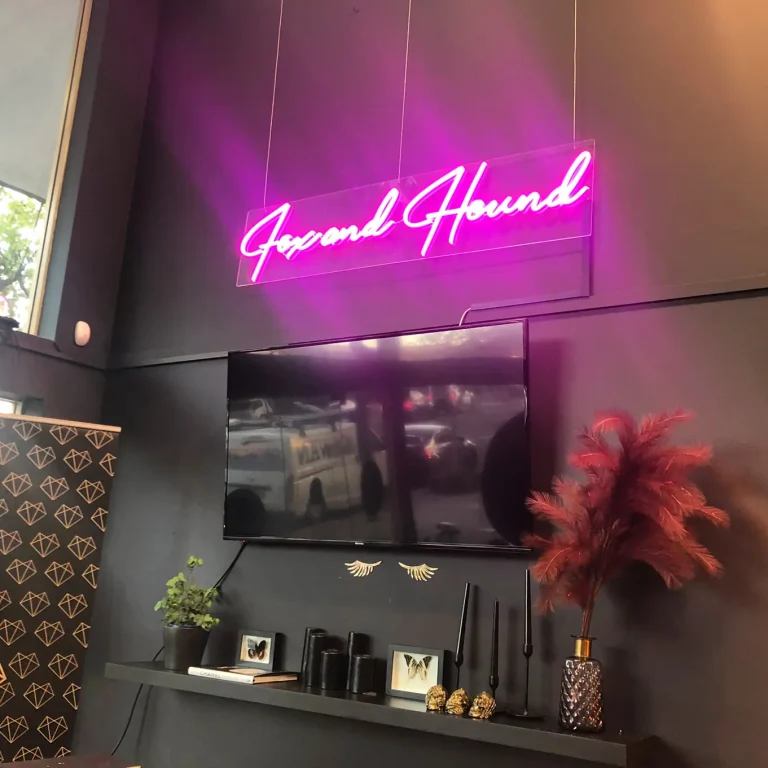 Pink script LED neon sign reading Fox and Hound displayed in a modern business interior in Australia