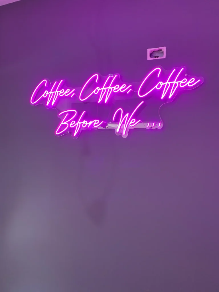 Purple script LED neon sign reading Coffee Coffee Coffee Before Life on dark background for Sydney cafe