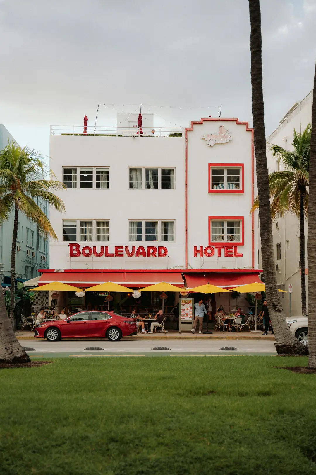 Pink Love neon sign with heart shape at Holiday Inn Cairns Harbourside against tropical plant wall