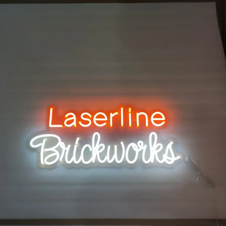 Orange and white LED neon sign reading Laserline Brickworks on a wall for business branding