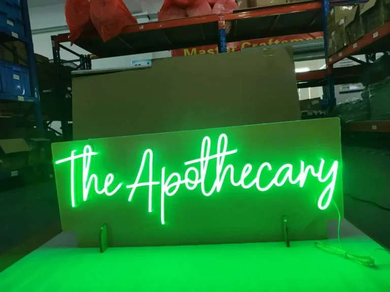 Close-up of a custom red LED neon sign with white light outlining the letters BEYO in a workshop setting