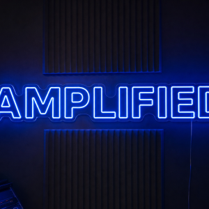 Amplified LED neon sign in bold clean sans-serif font in electric blue mounted on contour cut clear acrylic
