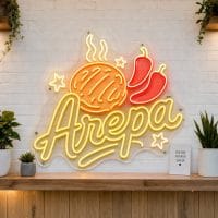 Arepa LED neon sign on clear acrylic backing mounted on white brick wall