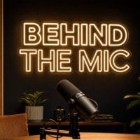 Behind The Mic Neon Sign Behind The Mic LED neon sign in warm white in cinematic podcast room with realistic microphone foreground