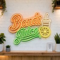 Bondi Juice LED neon sign on clear acrylic backing mounted on white brick wall