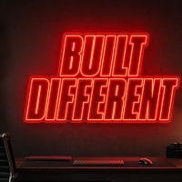 Built Different LED neon sign in red in industrial creator office with masculine high-performance aesthetic
