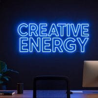 Creative Energy LED neon sign in blue in modern startup workspace with premium office styling