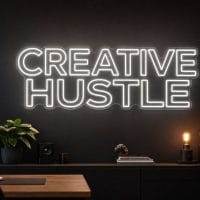 Creative Hustle LED neon sign in white in modern startup office with cinematic creator environment