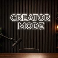 Creator Mode LED neon sign in white in modern YouTube studio with realistic filming setup