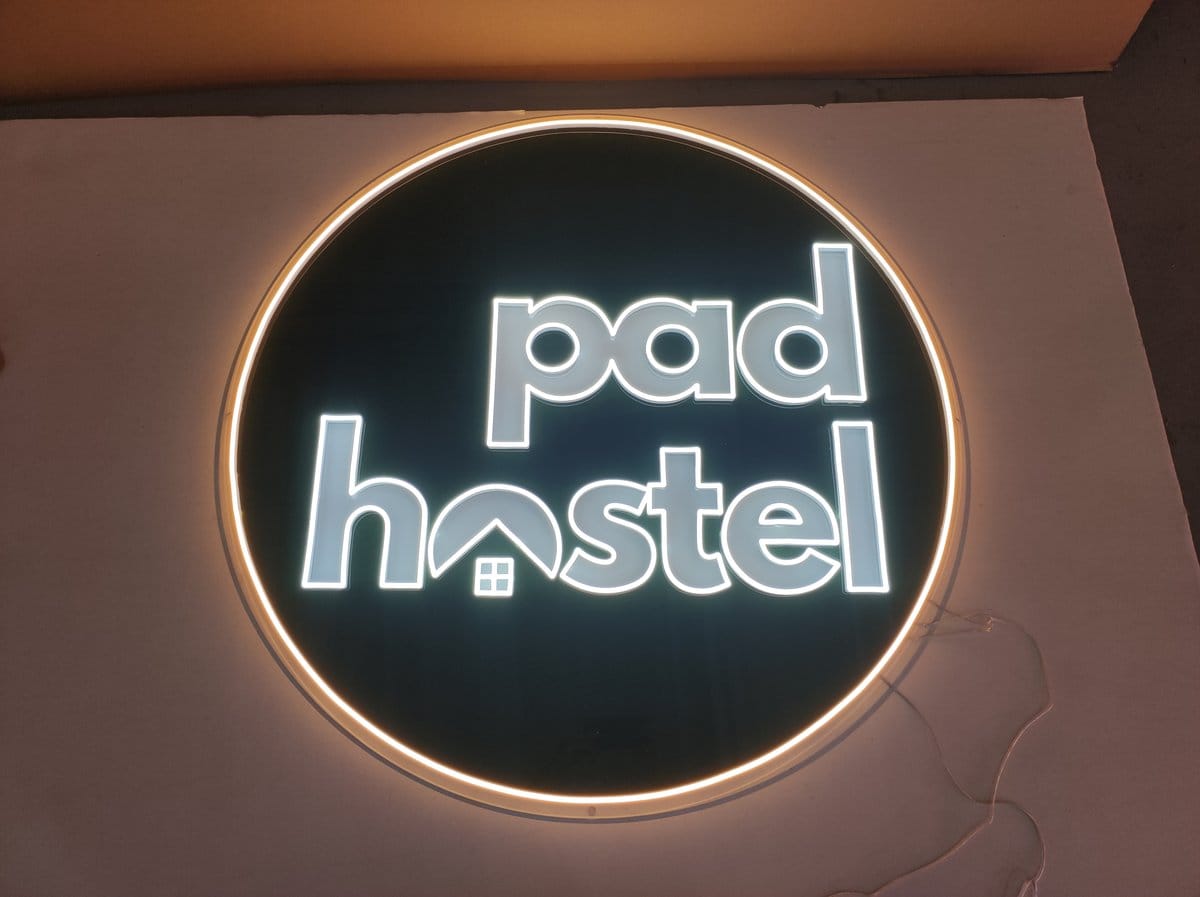 Custom pad hostel neon sign with house icon illuminated in Australia