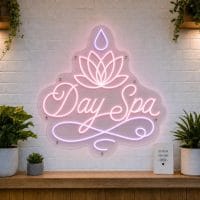 Day Spa LED neon sign with lotus flower icon on clear acrylic backing mounted on white brick wall
