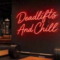 Red 'Deadlifts And Chill' neon sign mounted on a dark moody training space wall with cinematic lighting.