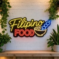 Filipino Food LED neon sign on clear acrylic backing mounted on white brick wall
