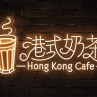 Hong Kong Cafe LED neon sign with milk tea glass and Chinese characters on dark wall