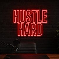 Hustle Hard LED neon sign in red in industrial black office with masculine creator vibe