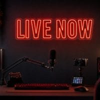 Live Now LED neon sign in deep red in dark creator streaming room