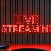 Live Streaming Neon Sign Live Streaming LED neon sign in red in streaming studio environment with realistic desk reflections