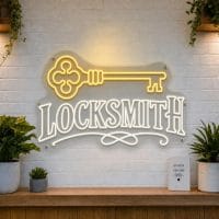 Locksmith LED neon sign with vintage key icon on clear acrylic backing mounted on white brick wall