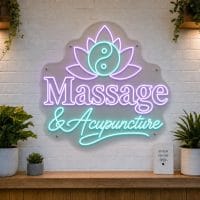 Massage and Acupuncture LED neon sign with lotus flower icon on clear acrylic backing mounted on white brick wall