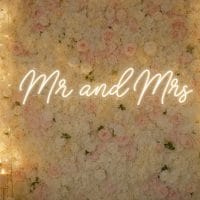 Custom Mr and Mrs LED neon sign for weddings and receptions. Contour-cut acrylic backing, silver scr