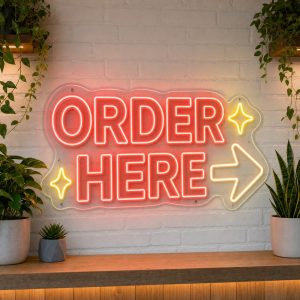 Order Here LED neon sign on clear acrylic backing mounted on white brick wall