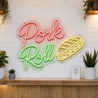 Pork Roll LED neon sign on clear acrylic backing mounted on white brick wall