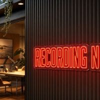 Recording Now Neon Sign Recording Now LED neon sign in red outside podcast booth in professional recording studio