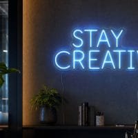 Stay Creative LED neon sign in ice blue in creative agency workspace with premium architecture