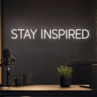 Stay Inspired LED neon sign in white in modern office setup with subtle architectural lighting