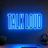 Talk Loud Neon Sign Talk Loud LED neon sign in electric blue in modern creator desk setup