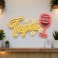 Tapas LED neon sign on clear acrylic backing mounted on white brick wall