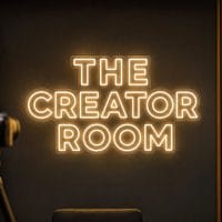 The Creator Room Neon Sign The Creator Room LED neon sign in warm white in cinematic filming setup with realistic cameras