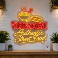 Vietnamese Authentic Street Food LED neon sign with pho bowl and banh mi icons on clear acrylic backing mounted on white brick wall
