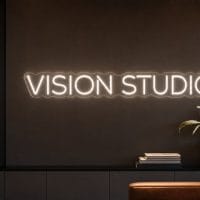 Vision Studio Neon Sign Vision Studio LED neon sign in white in creative agency environment with modern architecture