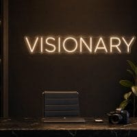 Visionary LED neon sign in warm white in luxury entrepreneur office with premium black interior